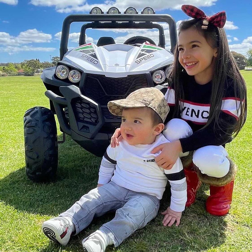 Little Riders 24V 4x4 beach buggy ride-on - big sister and baby brother in front of their white buggy
