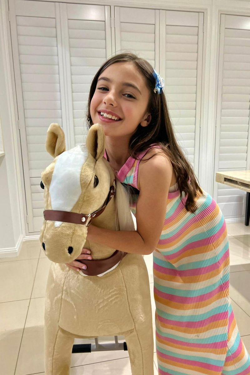 Little Riders light brown ride-on horse toy - girl hugging her light brown horse