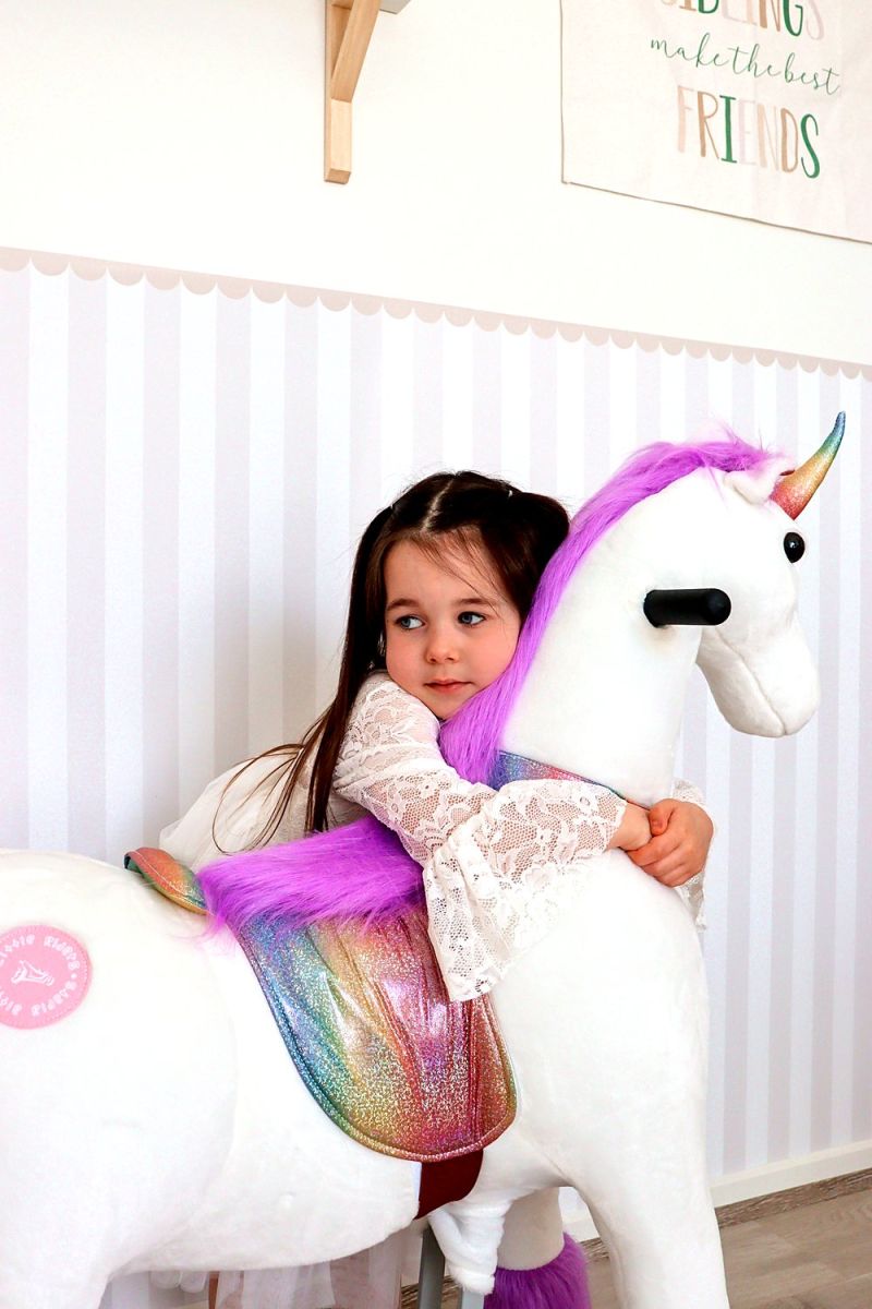 Little Riders unicorn ride-on toy - girl hugging her purple mane unicorn