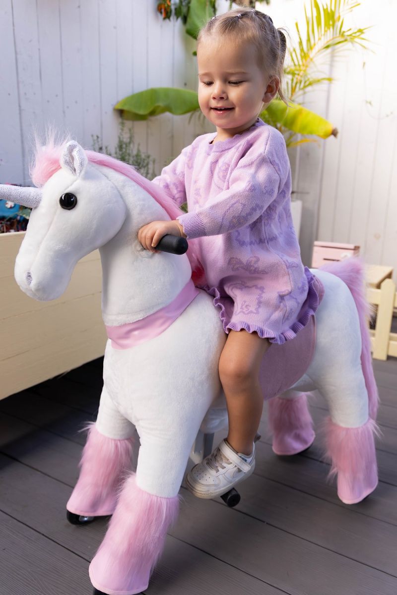 Little Riders pink unicorn ride-on toy - toddler riding her pink unicorn outdoors